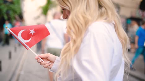 slow,motion:attractive young beautiful girl waves turkish flag and pulls arm of her boyfriend at narrow street in istanbul,turkey