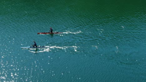 dos kayaks compitiendo uno al lado del otro en fila.