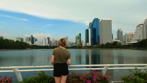 female tourist enjoying the views at benjakitti park, a popular urban recreational park in bangkok thailand with beautiful city views and scenic walking paths