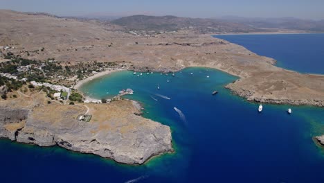 Aerial-view-of-a-beach-on-a-Greek-island-with-several-boats