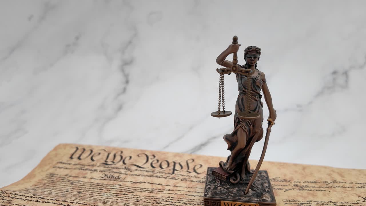 Simbolo potente di legge e democrazia, la Statua della Giustizia si erge in modo prominente di fronte alla Costituzione degli Stati Uniti, rappresentando equità, equilibrio e stato di diritto