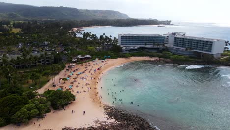 drone shot of turtle bay with people on beaches in oahu, hawaii