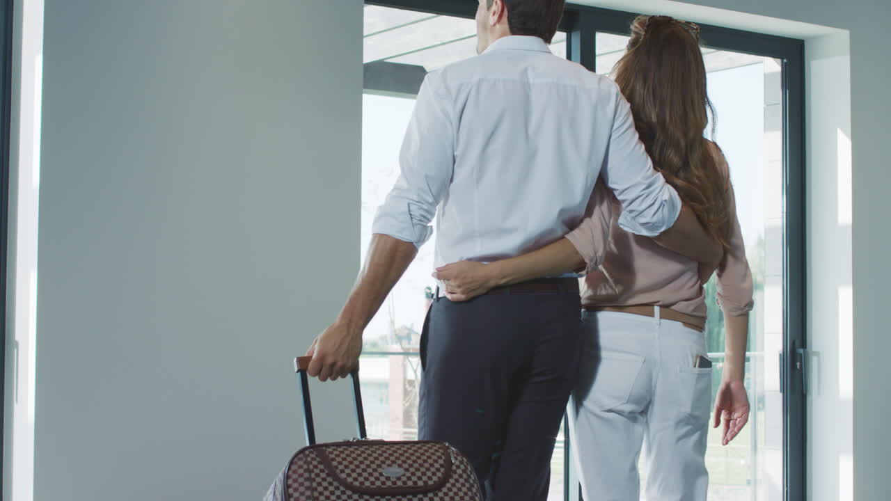 Pareja feliz con maleta regresando a casa. Pareja de viaje con maleta.