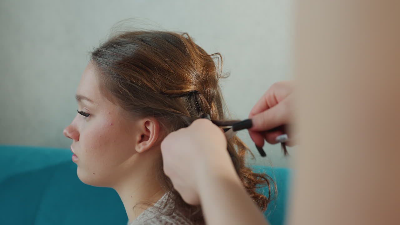 Young Woman Getting Braided Peacefully, Calm Scene Of Girl Receiving Expert Hairstyle, Relaxed Environment As Young Woman Receives Intricate Braid Styling From Skilled Professional