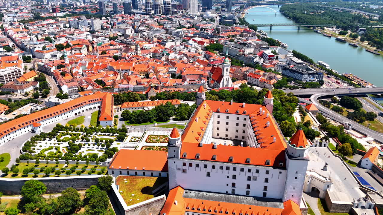 White Bratislava Castle overlooking the old town rooftops. Bratislava Castle rises above the old town with iconic red rooftops