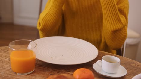 truck shot of a human taking a bite of a brioche placed on a clear dish