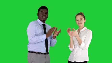 one businessman and one businesswoman applauding on a green screen, chroma key
