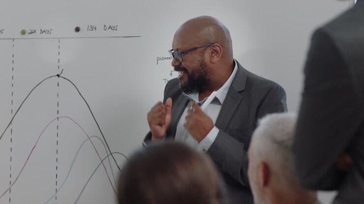 african american businessman presenting project development seminar showing diverse corporate management group ideas on whiteboard in startup office presentation