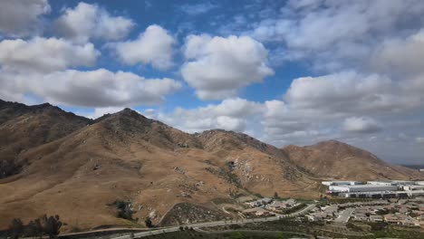 Una-Cautivadora-Toma-Desde-Un-Dron-Se-Adentra-Elegantemente-En-Una-Montaña-Majestuosa,-Enmarcada-Por-La-Belleza-De-Las-Nubes-Hinchadas-En-Lo-Alto,-Creando-Un-Paisaje-Sereno-Y-Espectacular.