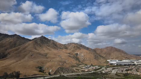 un cautivador drone disparado elegantemente empuja en una montaña majestuosa, enmarcado por la belleza de las nubes hinchadas por encima, creando un paisaje sereno y dramático