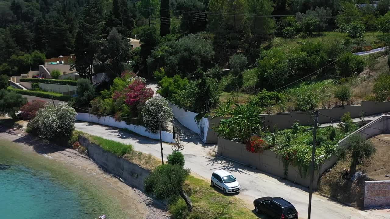 Tracking shot of a young woman riding her bike along the coast.