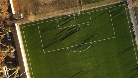 Vista-Aérea-De-Arriba-Hacia-Abajo-De-Los-Jugadores-De-Fútbol-Que-Juegan-El-Partido-En-El-Campo-De-Fútbol