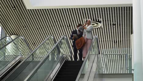 jóvenes de negocios en una escalera mecánica en un edificio moderno