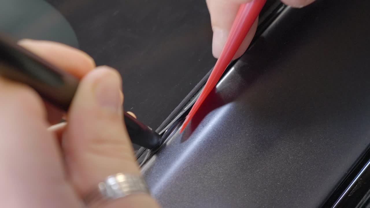 herramientas de plástico que empujan la película protectora de pintura en la costura del parabrisas del automóvil