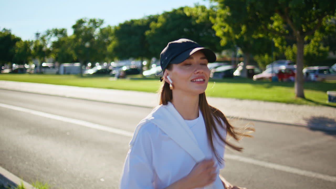 Active lady enjoy running at green street wearing black cap closeup