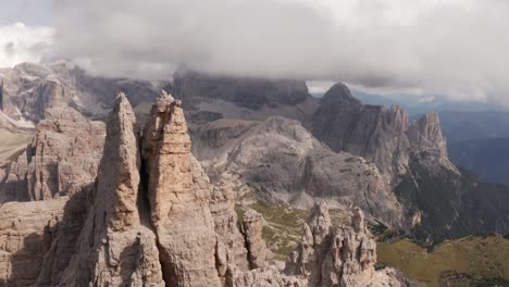 aerial moving over tre cime di lavaredo mountains with low clouds