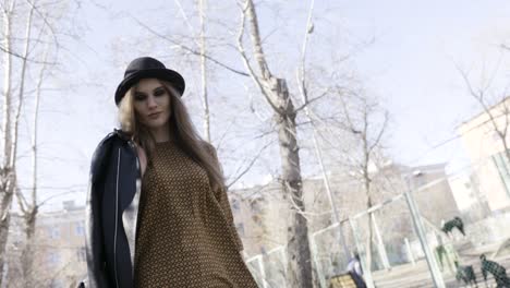 woman in stylish outfit walking in park