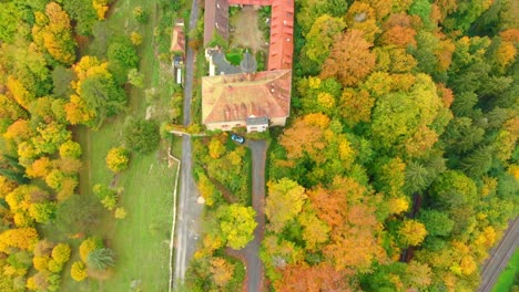 aerial drone shot of a castle in vibrant autumn colours 4k