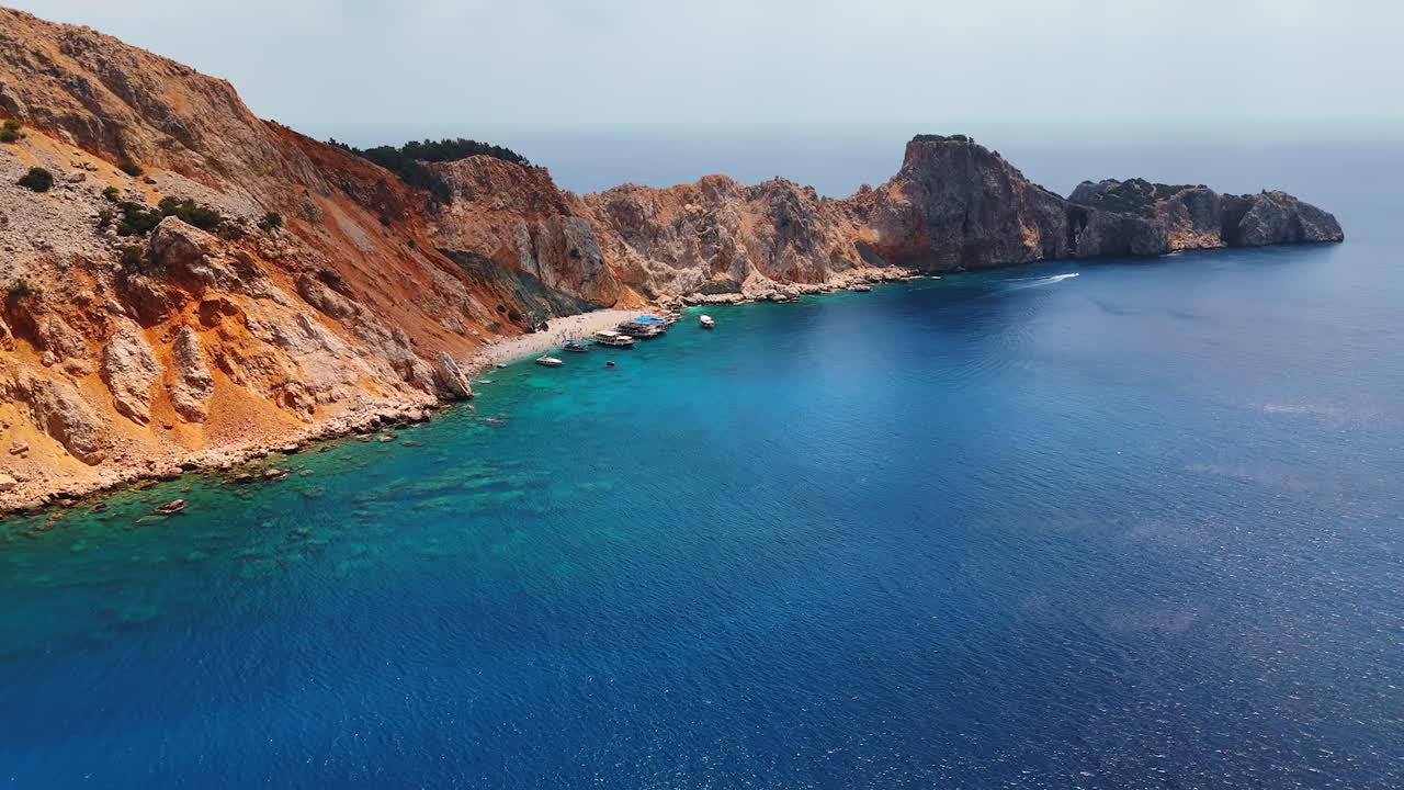 Coastal views of rugged cliffs. Vibrant turquoise waters meet rugged cliffs along a stunning coastline under clear skies, revealing a serene landscape