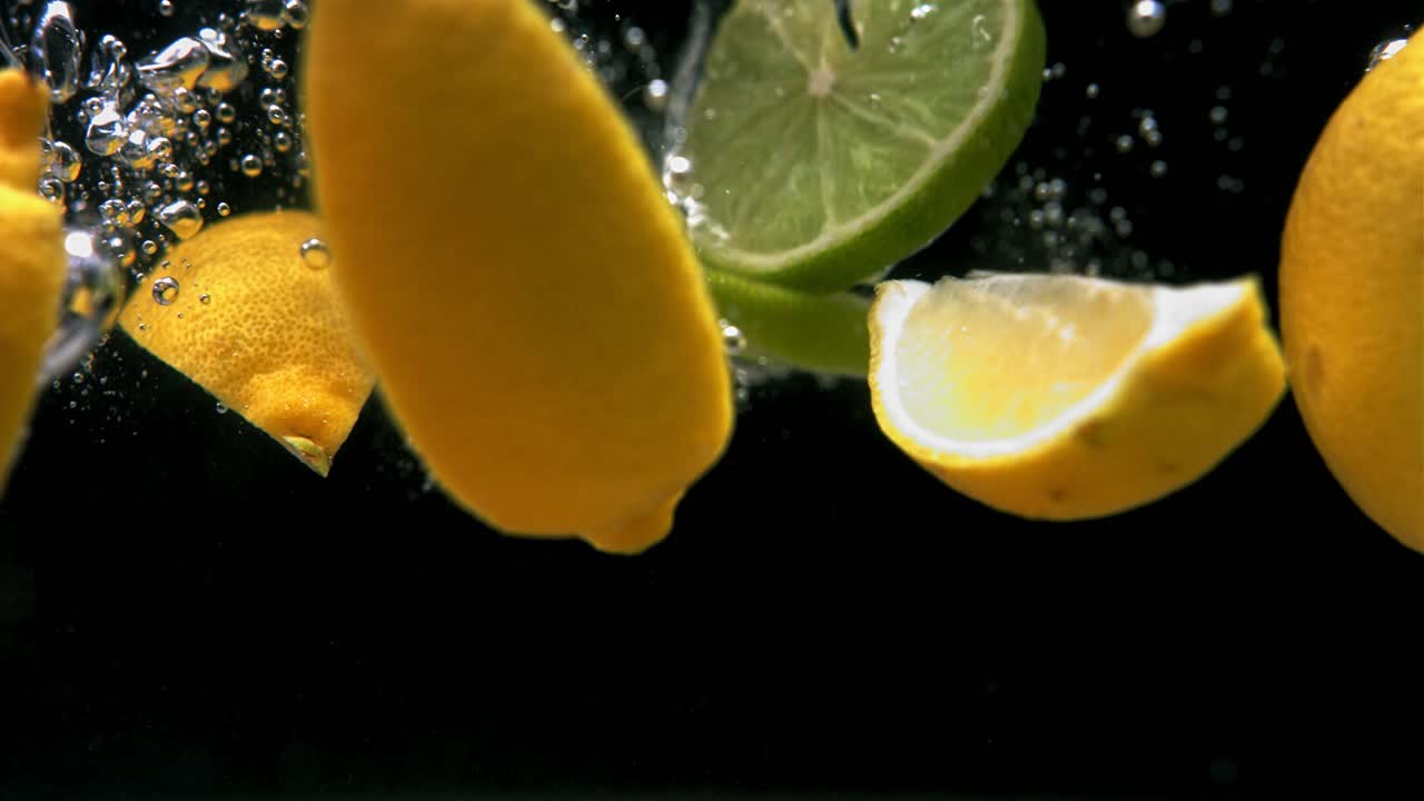 frutas cítricas salpicando en el agua