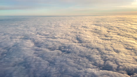 aerial shot from airplane over the clouds at sunrise