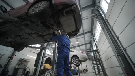 car mechanic replacing car wheel brake shoes of lifted automobile at repair service station