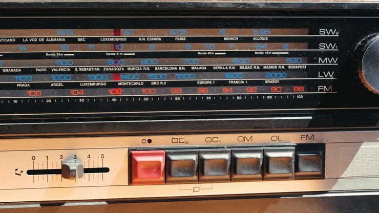 Vecchia radio AM FM retrò a valvole, mano che cambia stazione, lettore musicale vintage a valvole