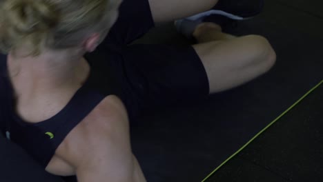 muscly man in home gym exercising lying down side ab crunch on floor