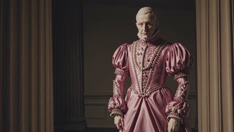 historical reenactment showing a nobleman wearing an elegant pink gown with pearl decorations, standing in a vintage interior with columns and curtains