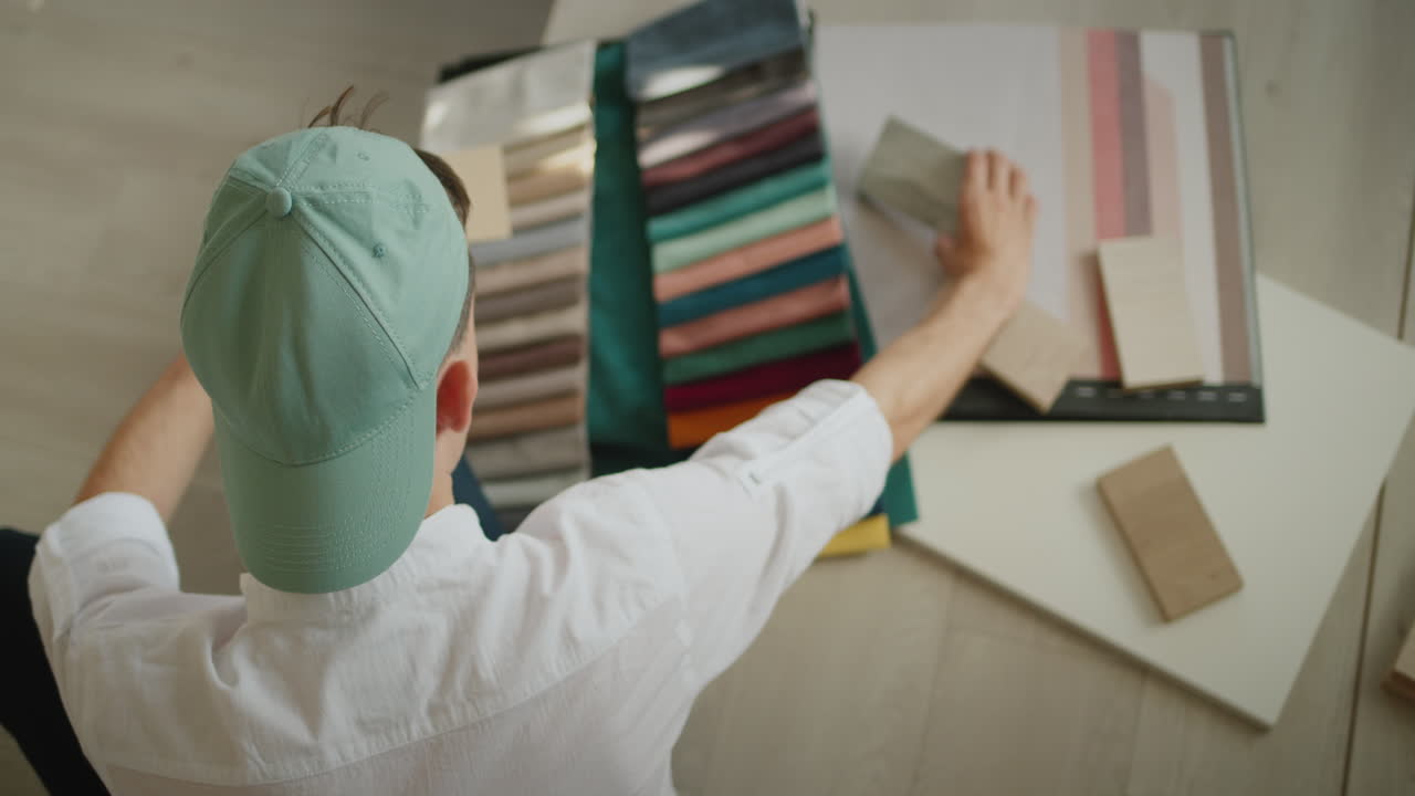 Creative professions - designer beats samples of fabric and wood, compares color and shade