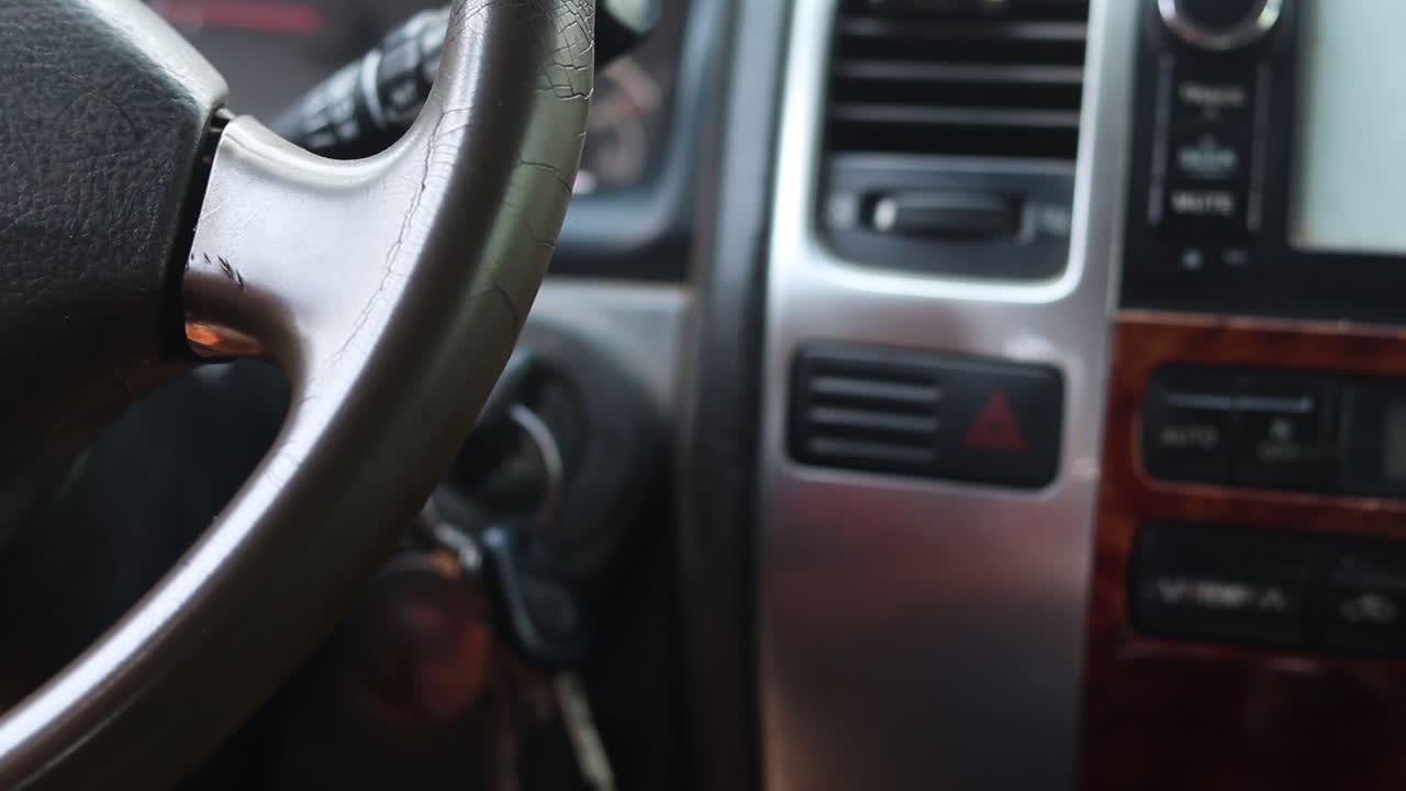 Male hand starting his car with a key. The man puts the key in the ignition and the vehicle starts