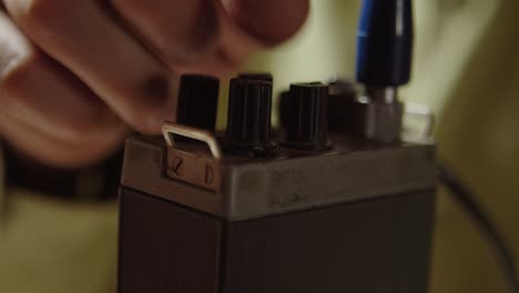 tuning or setting old walkie talkie, extreme closeup of finger and knobs