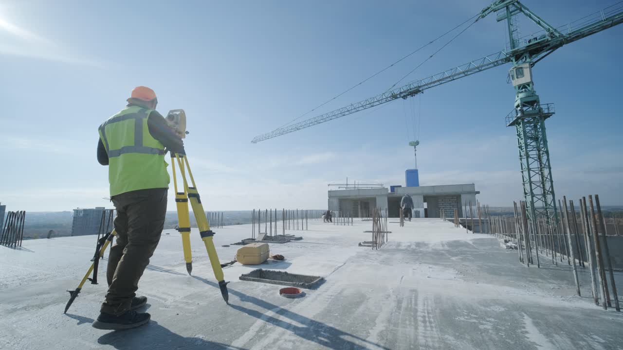 trabajos geodésicos. ingeniero topógrafo con ropa de protección y casco rojo utilizando equipo geodésico en el sitio de construcción. equipo profesional.
