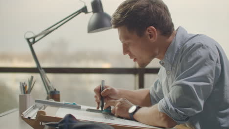 engineer draws buildings on the table using a pencil and ruler. an architect creates a building design on paper using a marker and ruler.