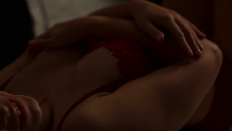 a beautiful woman wearing enticing lingerie sensually caressing her attractive body in slow motion