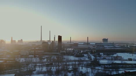 expansive, snow-covered industrial complex bathed in the soft glow of a sunrise or sunset