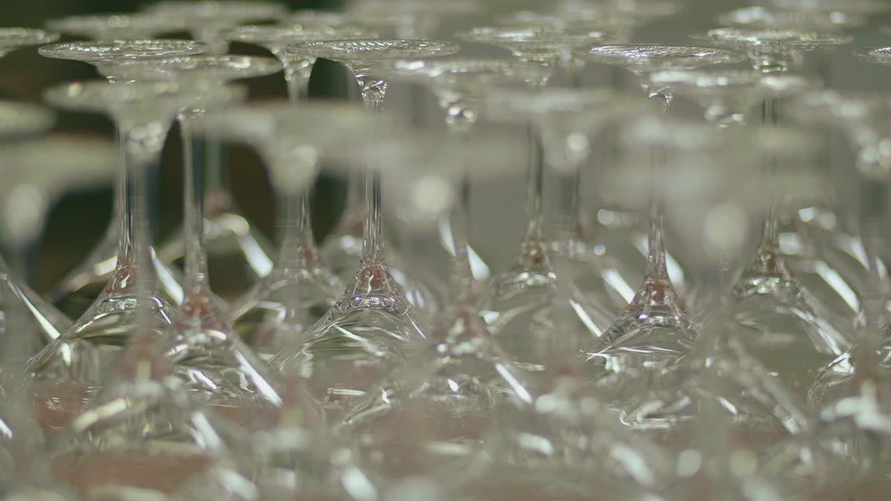 View of many up turned wine glasses ready for quality control in glass factory