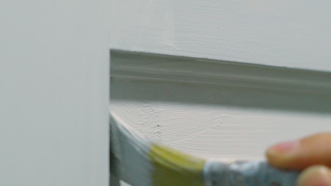 Close Up of Hand with Small Paintbrush Applying White Paint Decorating Home 4K