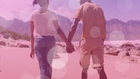 animation of light spots over african american couple walking and holding hands