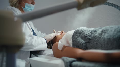 cosmetologist using facial steamer in beauty salon. closeup water reservoir