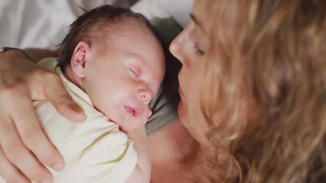 잠자는 신생아 와 함께 침대 에 누워 있는 행복 한 백인 어머니 의 비디오