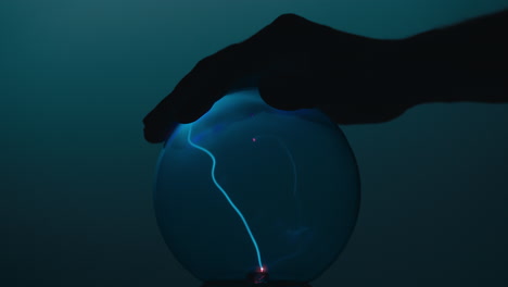 mano flotando sobre la bola de plasma