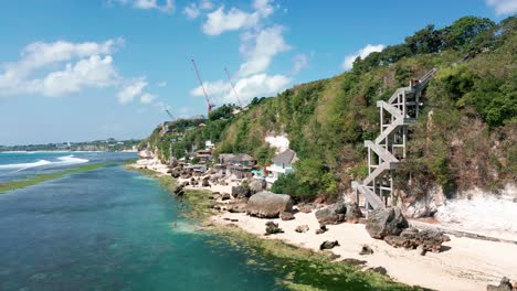 serene landscape of padang padang beach with rocky coastal cliff in bali, indonesia. aerial, wide shot