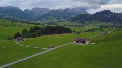 drone flying over verdant swiss valley with mountains in background