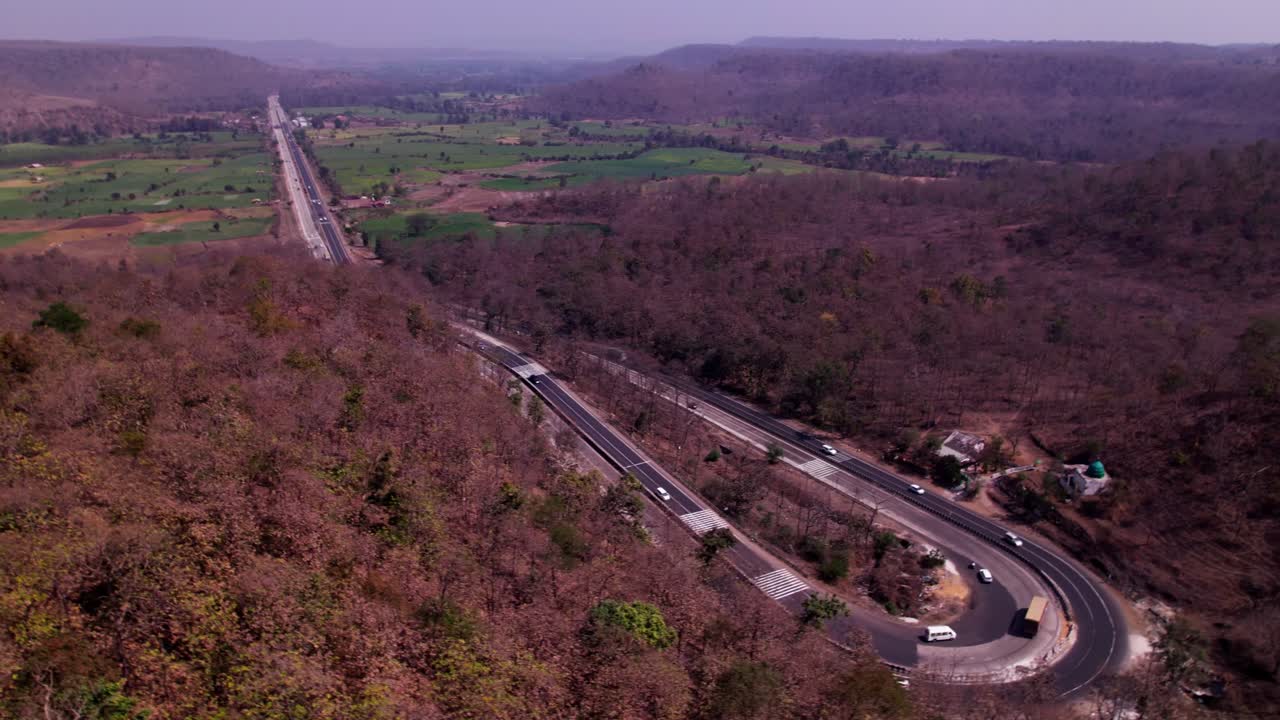 Forest with road and farming land at day time, push back, drone shot, 4k.