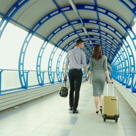 un hombre y una mujer van con equipaje a la terminal de la estación o del aeropuerto