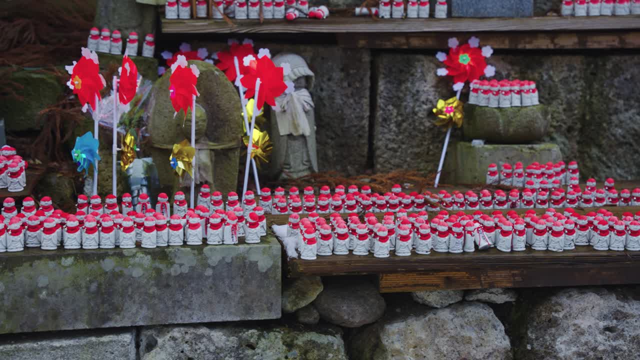 estatuas de guardianes jizo con pañuelos rojos mientras cae la nieve en el templo de yamadera, japón