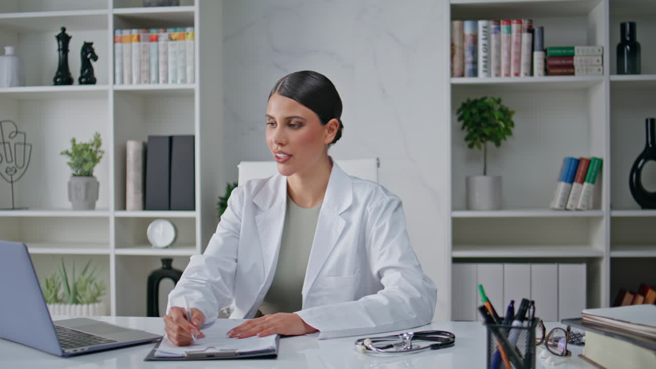 Doctor speaking online appointment by laptop sitting polyclinic office closeup