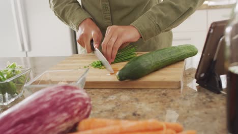 video of hands of biracial woman cutting chive