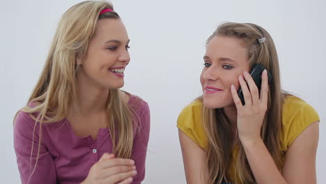 Woman-receiving-a-call-while-sitting-with-a-friend